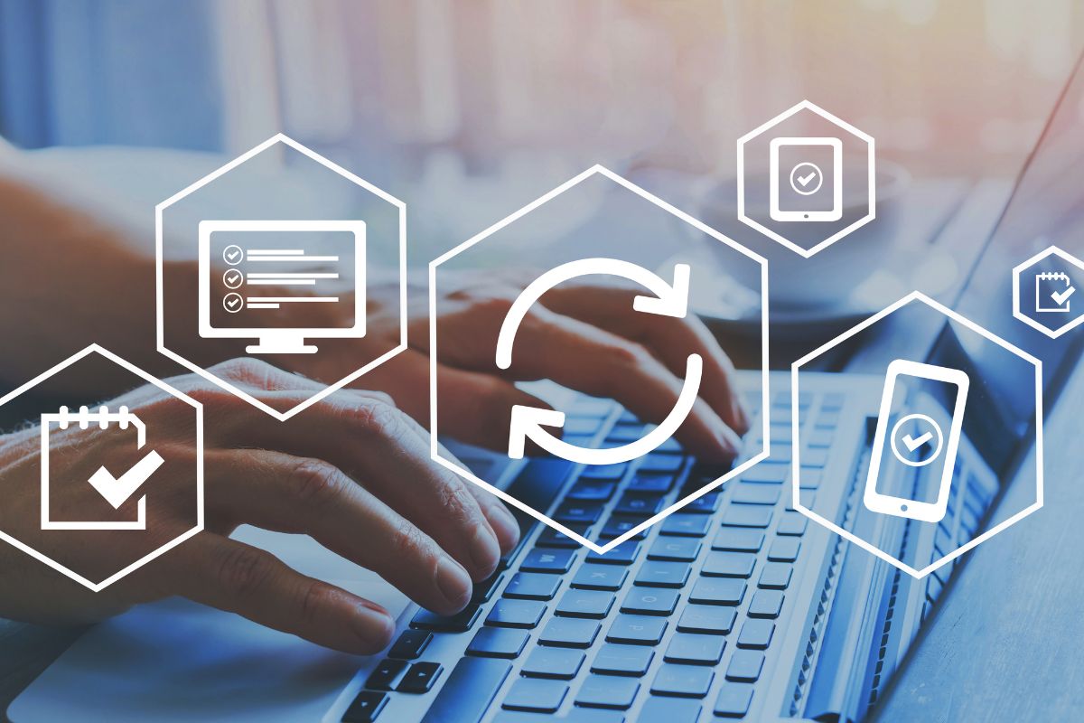 Hands typing on a laptop with workflow automation icons overlaid, representing digital transformation in CMT lab management.