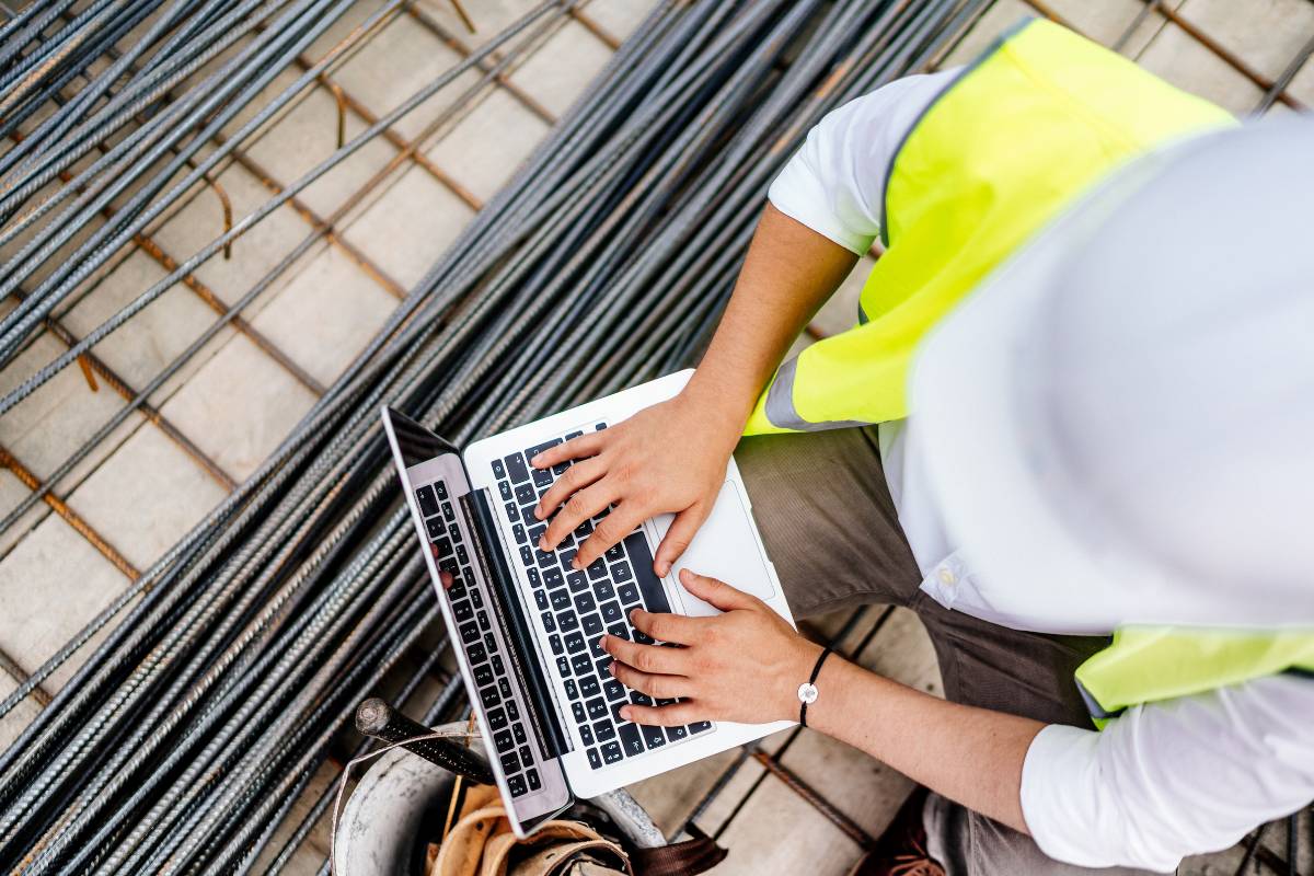 Engineer typing geotechnical reports on a laptop at a job site