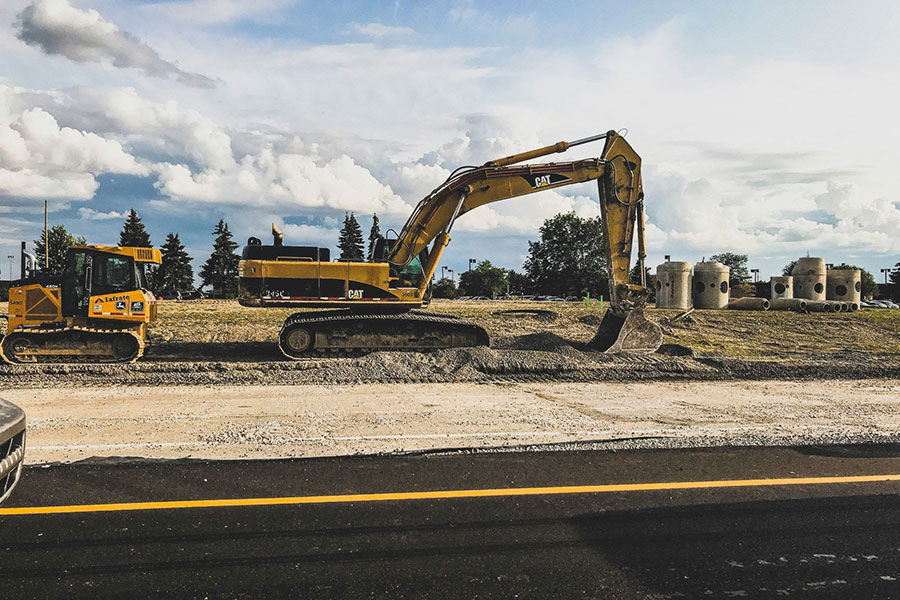 construction equipment digging soil with mountains in the background