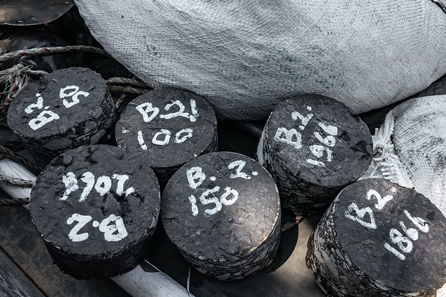 six asphalt cores with lab numbers written on them