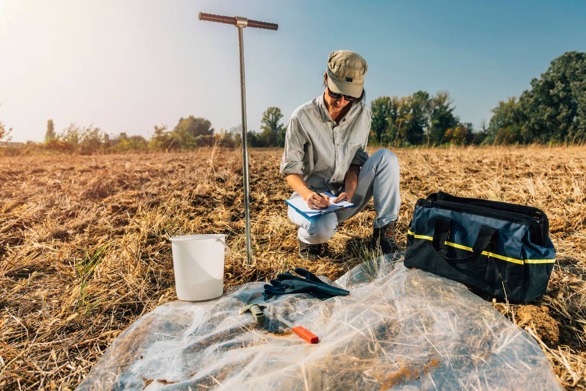 Construction materials testing technician performing soil compaction testing in the field
