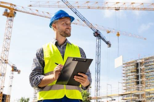 construction worker on a job site holding a checklist