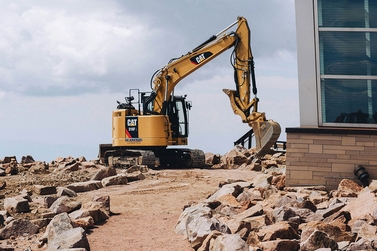 Construction site with concrete building frame and tower crane against blue sky