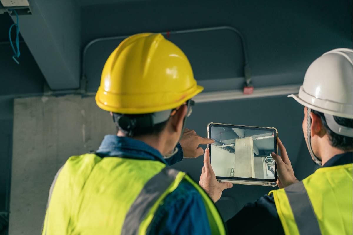 Two workers take inspection photos with a tablet