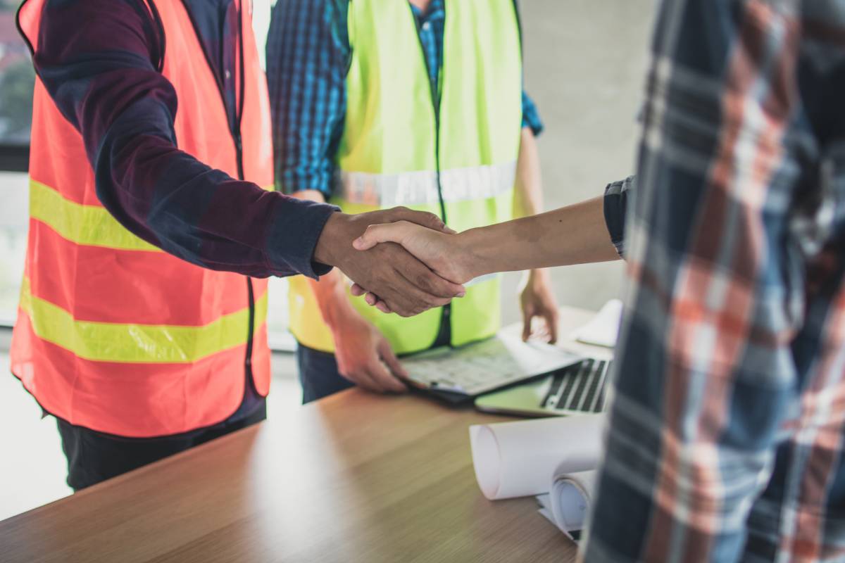 People around a desk shaking hands